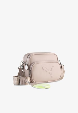 Bolso pequeño beige de bandolera con dos compartimentos con cremallera, logo Puma en el bolsillo frontal y correa ajustable con estampado y un lazo verde neón.