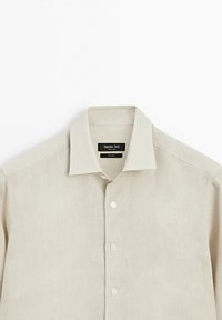 Beige linen long-sleeve shirt with collar and three buttons visible, labeled Massimo Dutti, laid flat on white background.