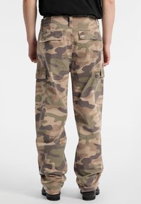 Cargo pants in een camouflagepatroon met verschillende tinten groen, bruin en beige, met zijzakken en een relaxte pasvorm.