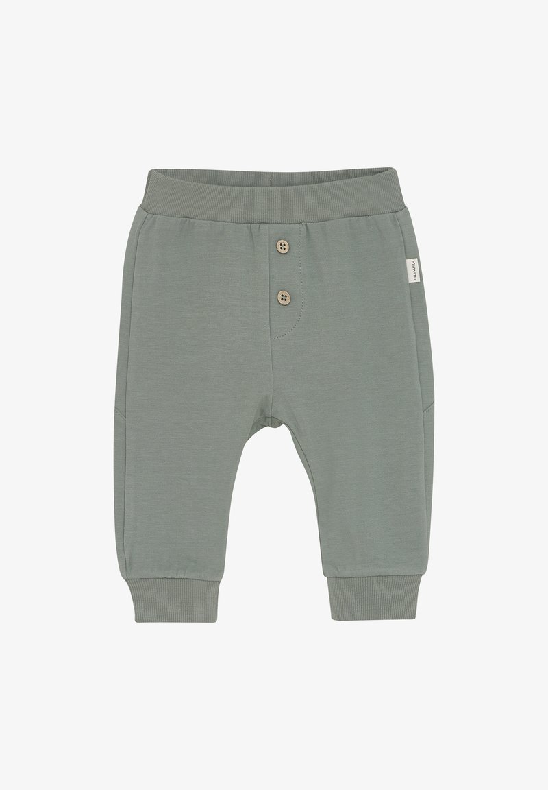 Groene katoenen broeken met geribbelde boorden, voorzien van twee houten knopen aan de voorkant en een klein wit label aan de zijkant. Zacht, casual ontwerp.