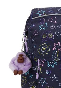 Mønstret rygsæk i flere farver med en navy stof, der har legende prikkede mønstre. En nøglekæde, der ligner en lilla gorilla, er vedhæftet.