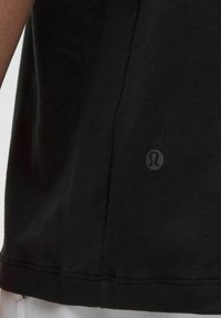 Tricou din bumbac negru, cu un logo subtil pe lateral, având o textură netedă și un gât clasic tip crew.