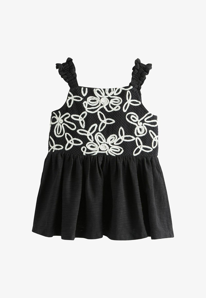 Robe noire sans manches avec bretelles à volants et motifs floraux brodés blancs sur le corsage, jupe froncée sous la taille.