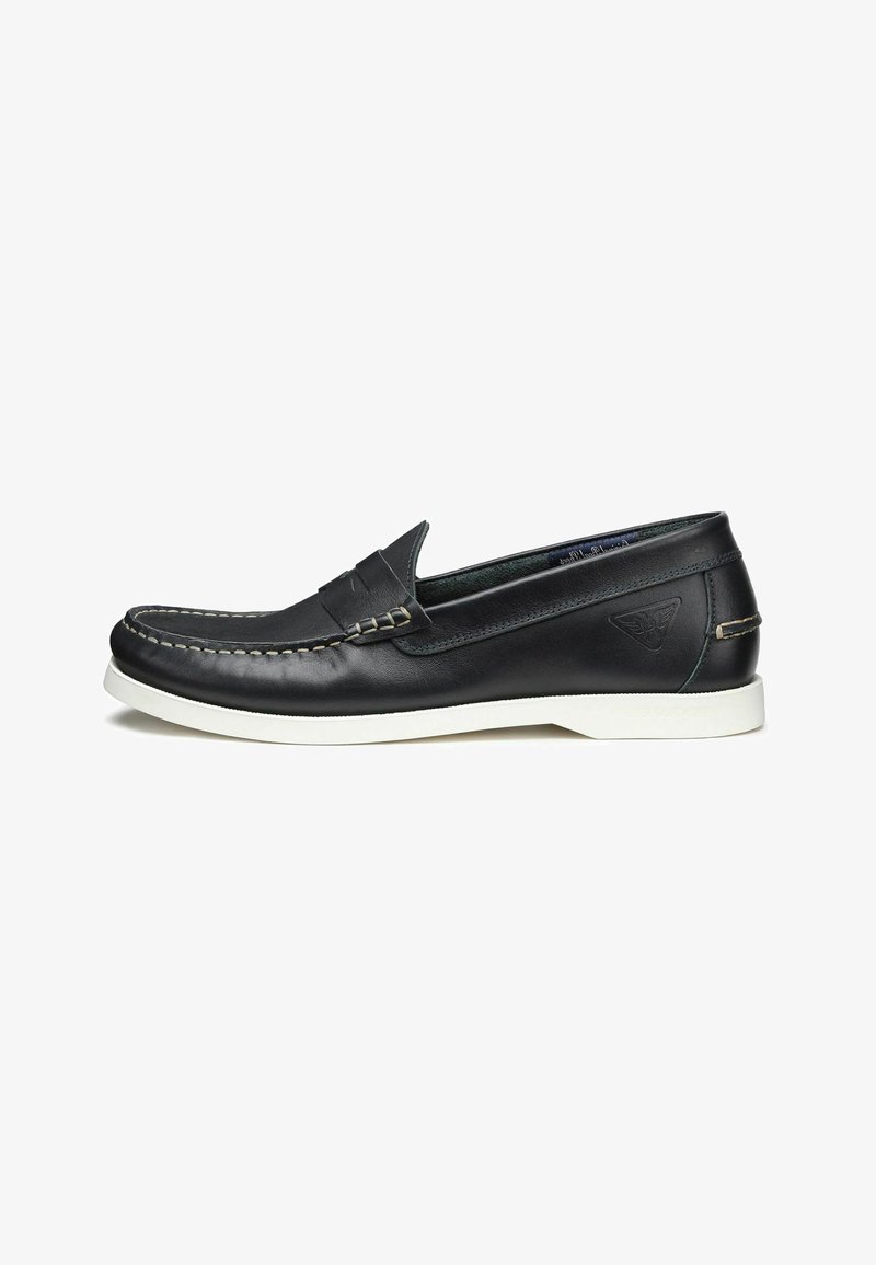Scarpa slip-on in pelle nera con suola in gomma bianca, cuciture dettagliate e design frontale stile mocassino. Presenta un piccolo logo sul tallone.