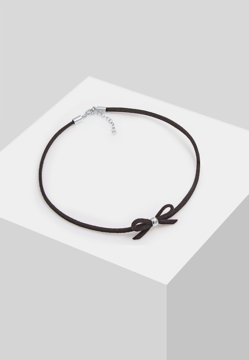 Sort ruskind choker med en lille sløjfe og sølvperle accenter. Har metalliske lukninger og en justerbar kæde til længdevariation.