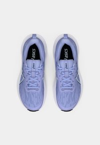 Αθλητικά παπούτσια σε ανοιχτό μωβ απόχρωση με υφή στην πάνω επιφάνεια, λευκή σόλα και γκρίζες λεπτομέρειες. Οίσαμε και το λογότυπο είναι ορατά στη γλώσσα.