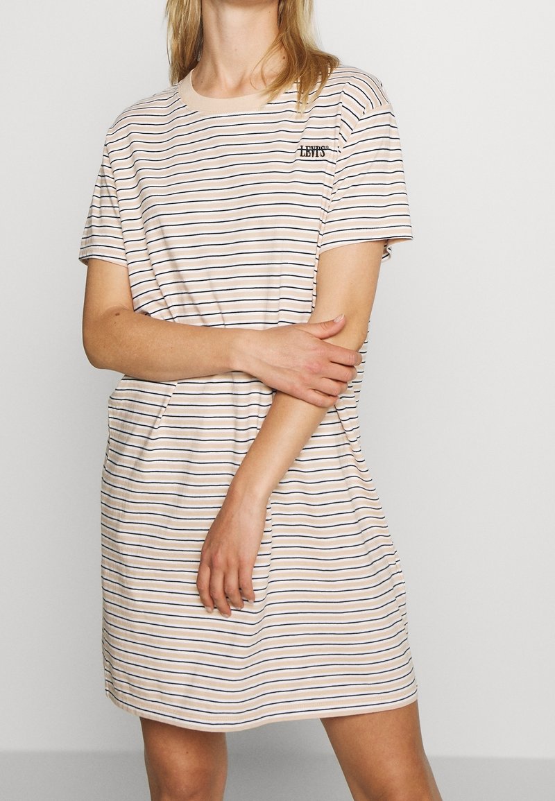 Tunika w paski w jasnym brzoskwiniowym i granatowym kolorze. Wykonana z miękkiej bawełny, z krótkimi rękawami i okrągłym dekoltem, posiada małe logo na piersi.