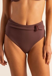 Bajo de bikini de tiro alto en tejido marrón con acanalado, que cuenta con una cinturilla ancha y una hebilla decorativa en la parte frontal. Textura suave.