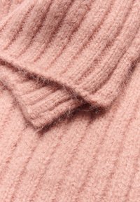 Tissu en laine tricotée rose avec une texture côtelée, présentant des fibres douces et une apparence en couches.