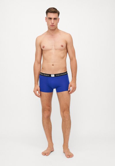Blue boxer briefs made of a smooth, stretchy fabric. Features a black waistband with white logo lettering. Form-fitting design.