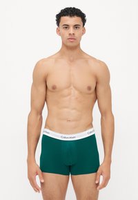 Groene katoenen trunk ondergoed met een witte elastische tailleband met het Calvin Klein-logo. Het ontwerp heeft een fitted stijl met een klassieke snit.