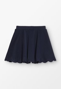 Tmavě modrá rozšířená sukně vyrobená z měkkého materiálu, s vlnitým lemem a výřezovými detaily. Lehká a nad kolena.