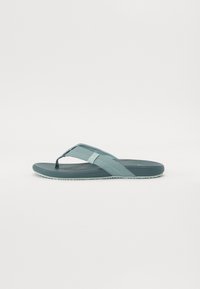 Lys blå flip-flop sandal med en teksturert fotbed, gummisåle og kryssrem-design. Har slitesterkt materiale for komfort og grep.