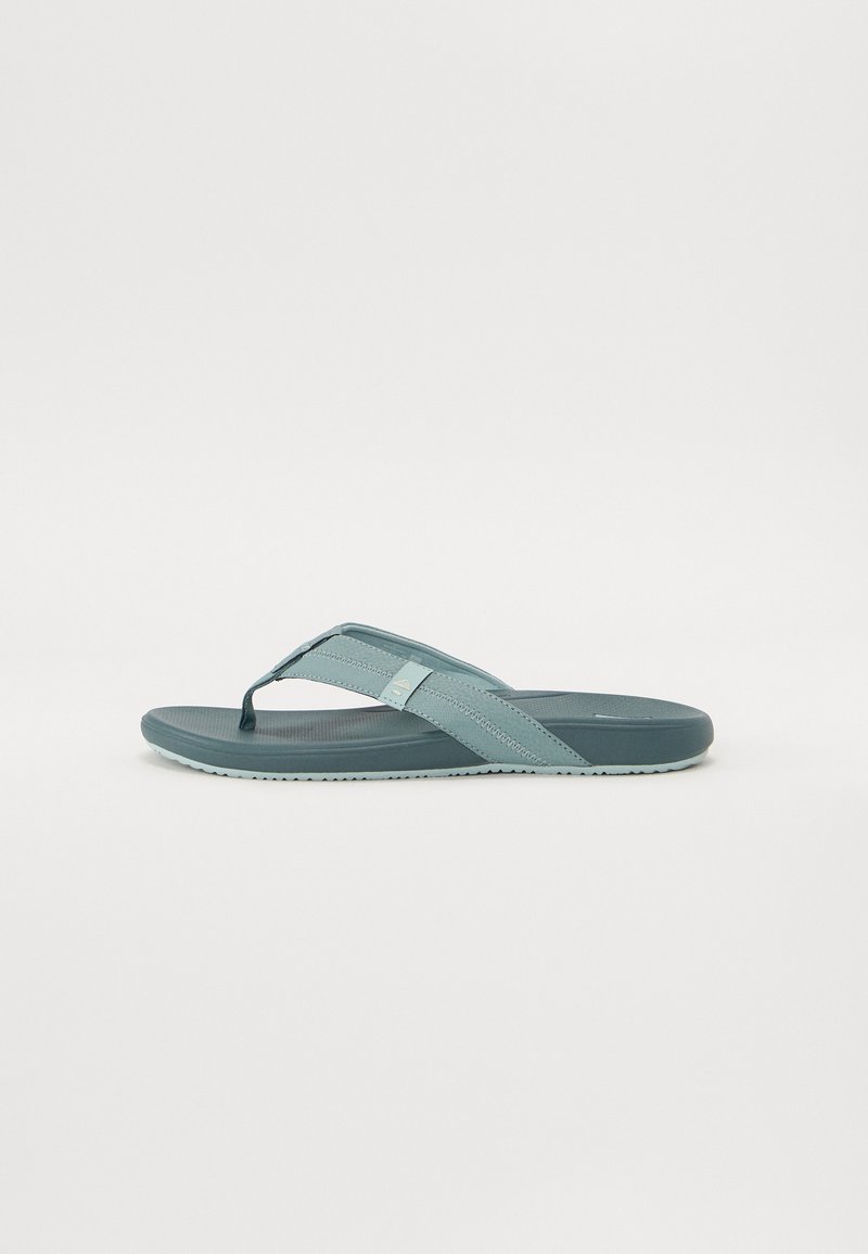 Lys blå flip-flop sandal med en teksturert fotbed, gummisåle og kryssrem-design. Har slitesterkt materiale for komfort og grep.