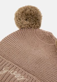 Berretto lavorato a maglia di colore marrone chiaro con due pompon soffici. Presenta un risvolto a coste e un dettaglio ricamato sul davanti. Tessuto testurizzato.