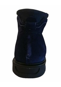 Botín de ante azul marino con un cuello texturizado negro, costuras reforzadas y una suela de goma duradera. La parte trasera cuenta con una pequeña pestaña en forma de bucle.