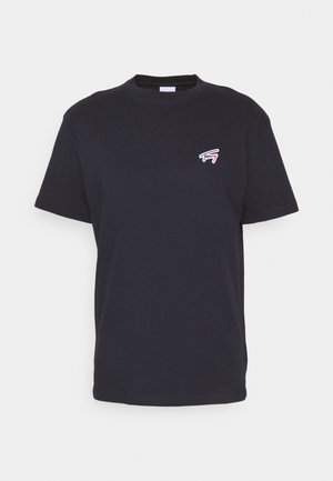 T-shirt noir à manches courtes avec col ras du cou, présentant un petit logo Tommy blanc et rouge sur la poitrine gauche, sur un fond uni.