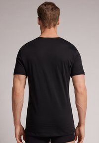 Zwarte crewneck t-shirt gemaakt van zacht katoen, slim-fit ontwerp, korte mouwen en een gladde textuur zonder zichtbare patronen of accenten.