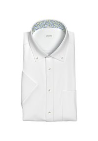 Camicia bianca con colletto a punta, caratterizzata da un colletto interno a motivo. Ha maniche lunghe e una tasca sul petto.