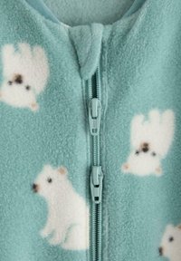 Fleece zip-up jakke i lys blå-grøn med hvide isbjørnemønstre. Har dobbelt lynlås og en blød tekstur.