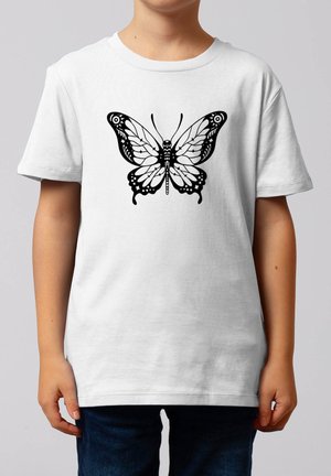 Kind trägt ein schlichtes weißes T-Shirt mit einem großen schwarzen Schmetterlingsmotiv in der Mitte der Brust.