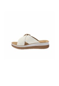 Sandalini in suede bianco con cinturini incrociati, soletta in sughero e suola in gomma marrone chiaro. Punta arrotondata e design contemporaneo.