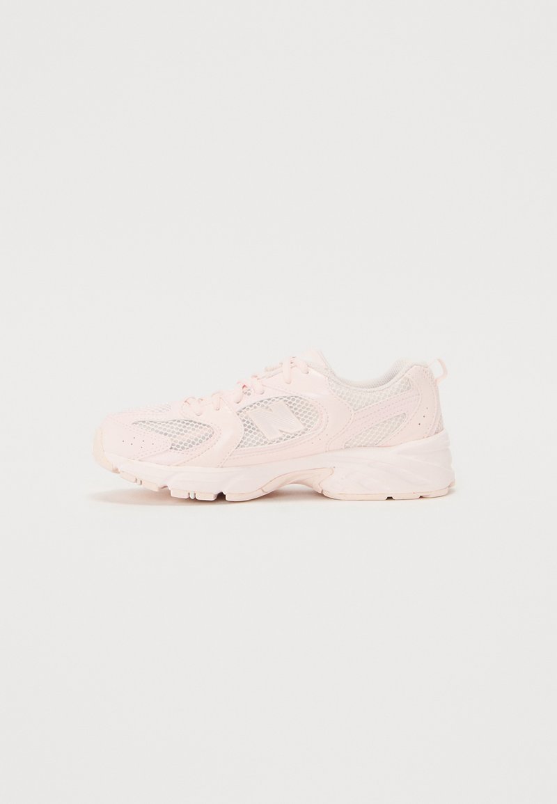 Baskets de sport rose clair avec tige en mesh, semelle rembourrée, bout rond et accents réfléchissants. Conçues pour le confort et la respirabilité.