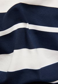 Marineblau und weiße gestreifte Stoff, weich und aus Baumwollmischung, mit auffälligen horizontalen Streifen in unterschiedlicher Dicke. Leichte Textur sichtbar.