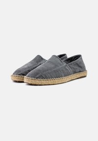 Sivé plátenné espadrilky s elastickým otvorom a juty tkanými podrážkami. Zaoblená špička, jednoduchý dizajn a plochá gumová podrážka.