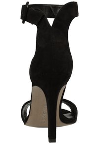 Sandal de tacón alto de ante negro con tira en el tobillo, parte posterior abierta y diseño curvado con una textura suave y mate.