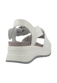 Sandalo bianco con cinturino posteriore, soletta in suede morbido, suola imbottita e suola in gomma grigia. Presenta bande elastiche regolabili per il comfort.