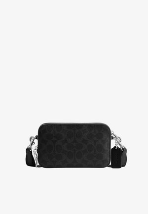 Sac bandoulière en cuir noir avec motif ovale texturé, fermeture éclair argentée, bandoulière amovible et deux porte-clés noirs sur fond blanc.
