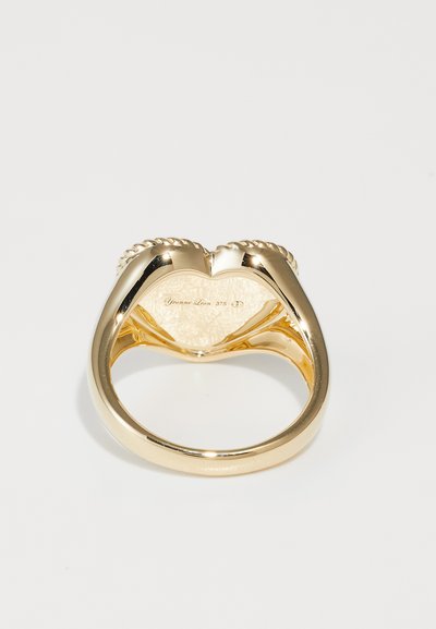 Zelta gredzens ar gludu apdari, ar savītas virves dizainu malās un iegravētu iekšējo joslu ar tekstūrētu detaļu.