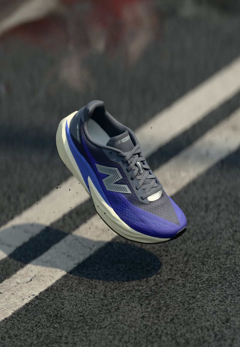 Sportschuh mit einem grauen und lila Mesh-Obermaterial, Schnürdesign und weißer Sohle. Mit einem auffälligen Logo und strukturierten Mustern auf der Oberfläche.