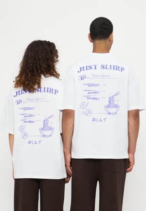Deux personnes portant des t-shirts blancs avec des illustrations bleues de bol de nouilles et de crevettes, avec le texte « Just Slurp » dans le dos.