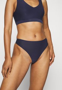 Marineblauw bikini set met een v-hals sportbeha en een high-waisted onderkant van gladde stof, met minimale naden en een comfortabele pasvorm.