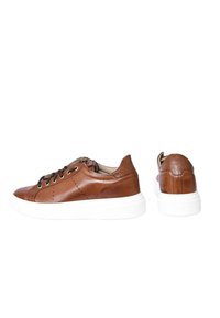 Sneaker in pelle marrone con suola in gomma bianca, caratterizzata da punta tonda, chiusura con lacci e delicate perforazioni sui lati.