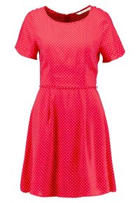 Robe à manches courtes, coupe trapèze, de couleur rouge vif avec des pois blancs, dotée d'un col rond et d'une taille cintrée avec un léger froncé.