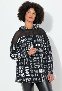 Sudadera negra con capucha de malla, con texto y patrones en blanco. Corte holgado con mangas largas, dobladillo sólido y estilo relajado.