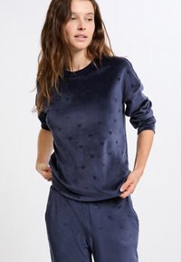 Granatowy welurowy sweatshirt z teksturowanymi wzorami serc, okrągłym dekoltem oraz długimi rękawami, w zestawie z pasującymi spodniami.