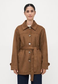 Braune Wildlederjacke mit Kragen, Knopfleiste, Gürtel und seitlichen Taschen. Besitzt eine glatte Textur und eine lockere Silhouette.
