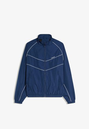 Marineblaue Jacke mit Reißverschluss, weißen Paspeldetails, hohem Kragen, elastischen Bündchen, Saum und Taschen auf beiden Seiten.