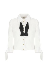 Blusa bianca con maniche lunghe, bottoni dorati e dettaglio di cravatta in raso nero al colletto. Presenta polsini legati e una vestibilità sagomata.