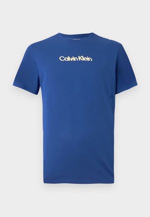 T-shirt blu in cotone con colletto a girocollo, maniche corte e logo dorato di Calvin Klein sul petto. Texture liscia, design casual.