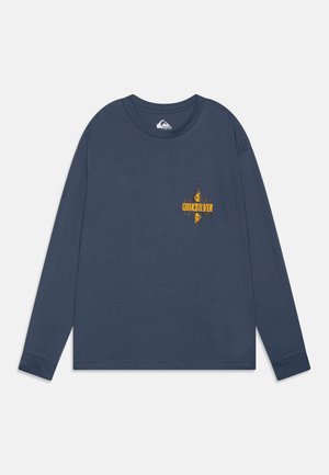 Camisa de manga larga en azul marino, hecha de tela suave. Presenta un gráfico en forma de diamante y texto en amarillo y beige en el pecho.
