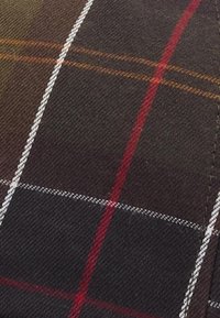 Καρό ύφασμα με σκούρο καφέ φόντο και κόκκινες, λευκές και πορτοκαλί ρίγες σε σχέδιο πλέγματος. Υφαντό με υλικό από βαμβακερό μείγμα.