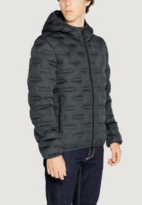 Giacca a vento in grigio scuro con un motivo testurizzato, dotata di cappuccio e tasche con zip, realizzata in un materiale leggero e isolante.