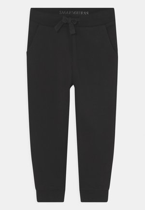 Sorte afslappede joggebukser med elastik i taljen, snøre, sidelommer og ribkanter ved anklerne.