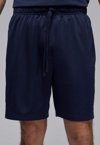 Bermudas atléticas en azul marino hechas de tejido de malla transpirable, con una cintura elástica y cordón ajustable, y un corte relajado.