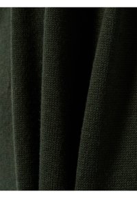 Donkergroene gebreide stof met een zachte textuur, met een close-up van de weving en lichte variaties in tint.